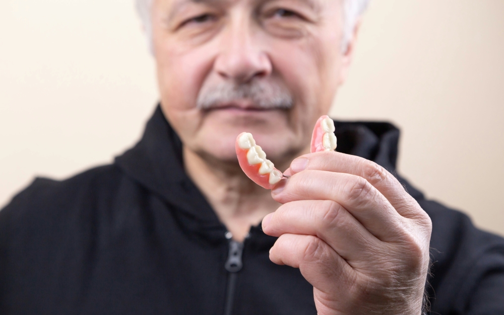 Man holding dentures